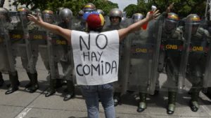 Venezuela's economic crisis, protesting woman stands in front of riot police in Caracas, Venezuela.